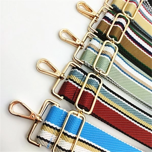 Detail of adjustable woven striped bag straps with premium gold metal hardware hooks