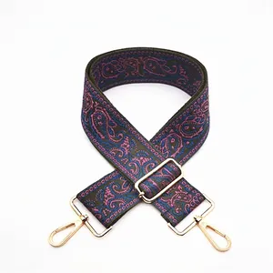 Detail of bohemian paisley embroidered wide bag strap with gold metal lobster clasps