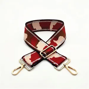 Detail of adjustable wide camouflage strap with golden lobster clasp and silver accents