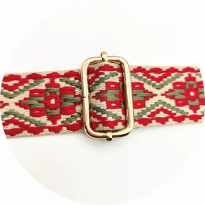 Macro shot of ethnic floral woven strap with adjustable golden metal buckle detail
