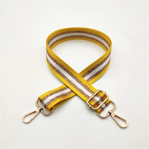 Détail d'une bandoulière ajustable jaune et blanche avec bande pailletée rose dorée