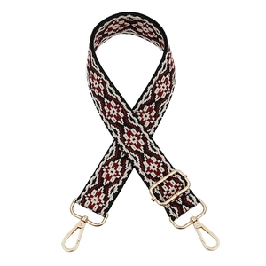 Detailed view of geometric ethnic woven strap with gold metal buckles and lobster clasps