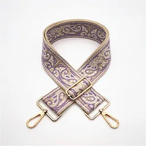 Detail of adjustable paisley weave bag strap with premium light gold metal swivel hooks