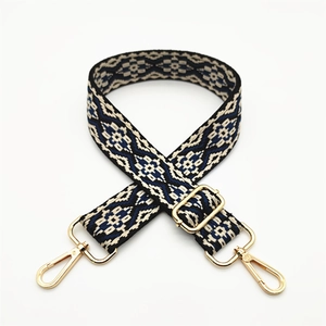 Detail of adjustable geometric ethnic woven bag strap with golden metal swivel hooks