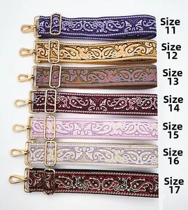 Close-up of ethnic paisley woven bag straps with adjustable gold metal hooks and buckles