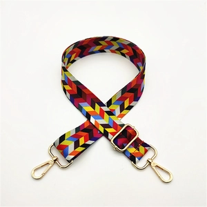 Adjustable chevron patterned bag strap with golden swivel lobster clasps on white background