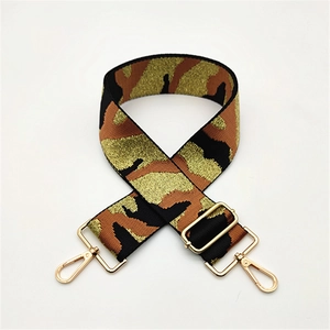 Macro shot of camo wide shoulder strap with golden metal swivel lobster clasps