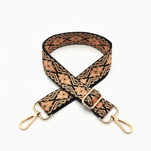 Close-up of ethnic geometric woven strap with gold metal rotating hooks and buckle