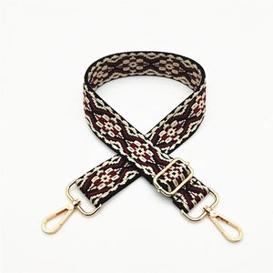 Close-up of ethnic geometric pattern woven strap with gold adjustable metal buckles
