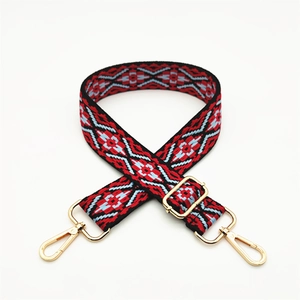 Detail of adjustable ethnic geometric woven strap with golden metal lobster clasps