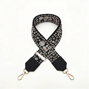 Detail of floral embroidered shoulder strap with gold metal hooks and adjustable buckle