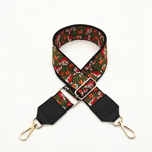 Detailed view of ethnic embroidery purse strap with floral patterns and gold lobster clips