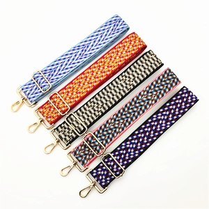 Detail view of five assorted colorful woven bag straps with golden metal hooks and hardware