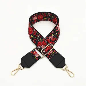 Close-up of ethnic style wide strap with pink floral embroidery and golden metal hooks