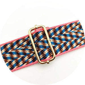 Close-up of colorful woven shoulder strap with golden metal adjustment buckle