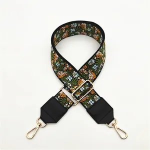 Detail of floral ethnic embroidery on black wide strap with gold metal swivel hook