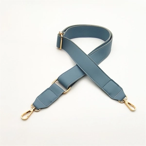Detail of fog blue PU leather bag strap with golden metal swivel hooks and buckle