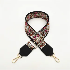 Close-up of ethnic style embroidered bag strap with floral patterns and gold hooks