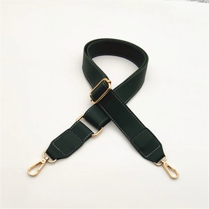 Close-up of dark green PU leather bag strap with white stitching and gold metal buckle