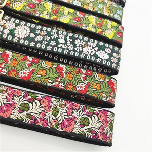 Close-up of ethnic style embroidered bag straps with colorful patterns and golden hooks