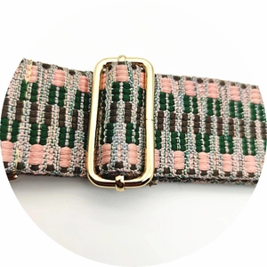 Détail macro d'une sangle tissée géométrique avec boucle réglable en métal doré