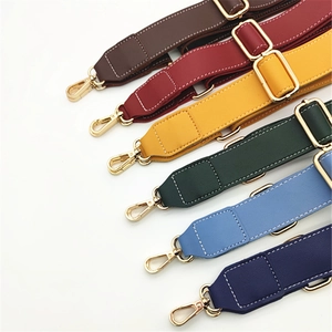 Detail showing adjustable PU leather shoulder straps with litchi texture and gold buckles