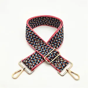Detail of colorful geometric woven bag strap with golden metal lobster clasps