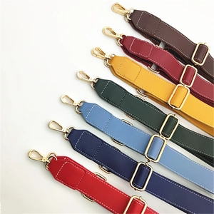 Close-up of colorful PU leather bag straps with golden hooks and white stitching detail
