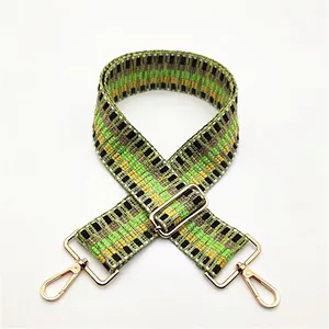Détail de la bandoulière tissée aux motifs géométriques vert et jaune avec mousquetons dorés