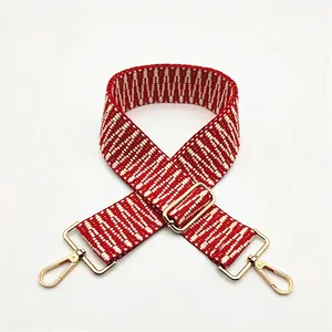 Détail de la sangle tissée géométrique rouge et blanc avec fermoirs dorés en métal