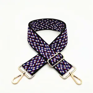Detail view of woven shoulder strap with red, white, blue wavy pattern and gold clasps