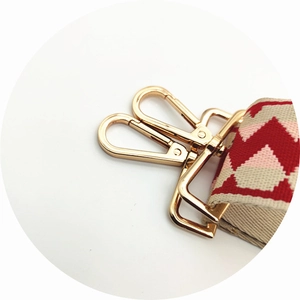 Detail of red geometric wave pattern strap with polished gold lobster clasps