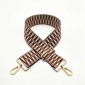Détail de la bandoulière tissée n° 31 avec motif géométrique marron et boucles dorées