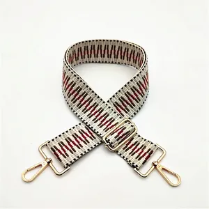 Détail de la bandoulière tissée style ethnique avec motifs géométriques et crochets dorés