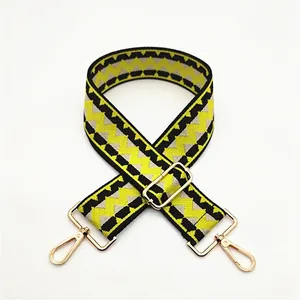 Close-up of wide geometric pattern bag strap with gold metal rotating hooks