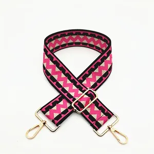 Detail of pink and black geometric woven wide shoulder strap with gold metal lobster clasp