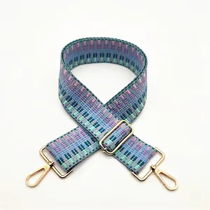 Macro shot of colorful geometric woven bag strap with golden metal hardware adjusters