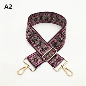 Close-up of ethnic purple jacquard bag strap with adjustable gold metal hardware