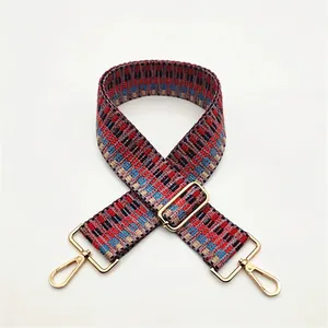 Close-up of woven ethnic geometric strap with gold metal lobster clasps and buckles