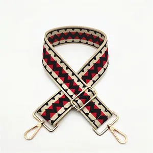 Detail of adjustable geometric diamond pattern bag strap with gold metal spring hooks