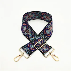 Close-up of ethnic style paisley pattern bag strap with adjustable gold metal buckles