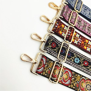Detailed view of adjustable ethnic embroidery purse straps with gold metal hardware hooks