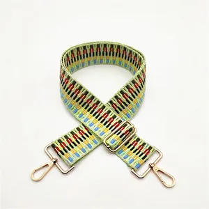 Macro detail of a colorful woven replacement shoulder strap with gold metal lobster clasps