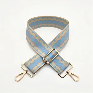 Detail of wide replacement bag strap with blue and beige geometric wave pattern