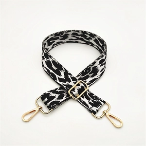 Detail showing leopard print fabric strap with gold metal lobster clasps and slider