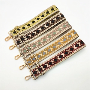 Close-up of five bohemian embroidered canvas straps with gold metal hardware