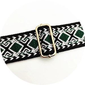 Detail view of woven diamond pattern bag strap with gold adjustable metal buckle