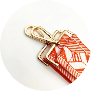 Macro view of geometric diamond weave bag strap with premium gold metal swivel hooks