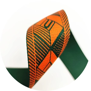 Macro view of geometric jacquard orange and green adjustable shoulder strap webbing