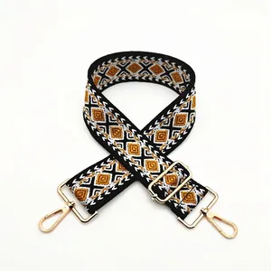 Detail view of ethnic geometric jacquard bag strap with gold metal lobster clasps